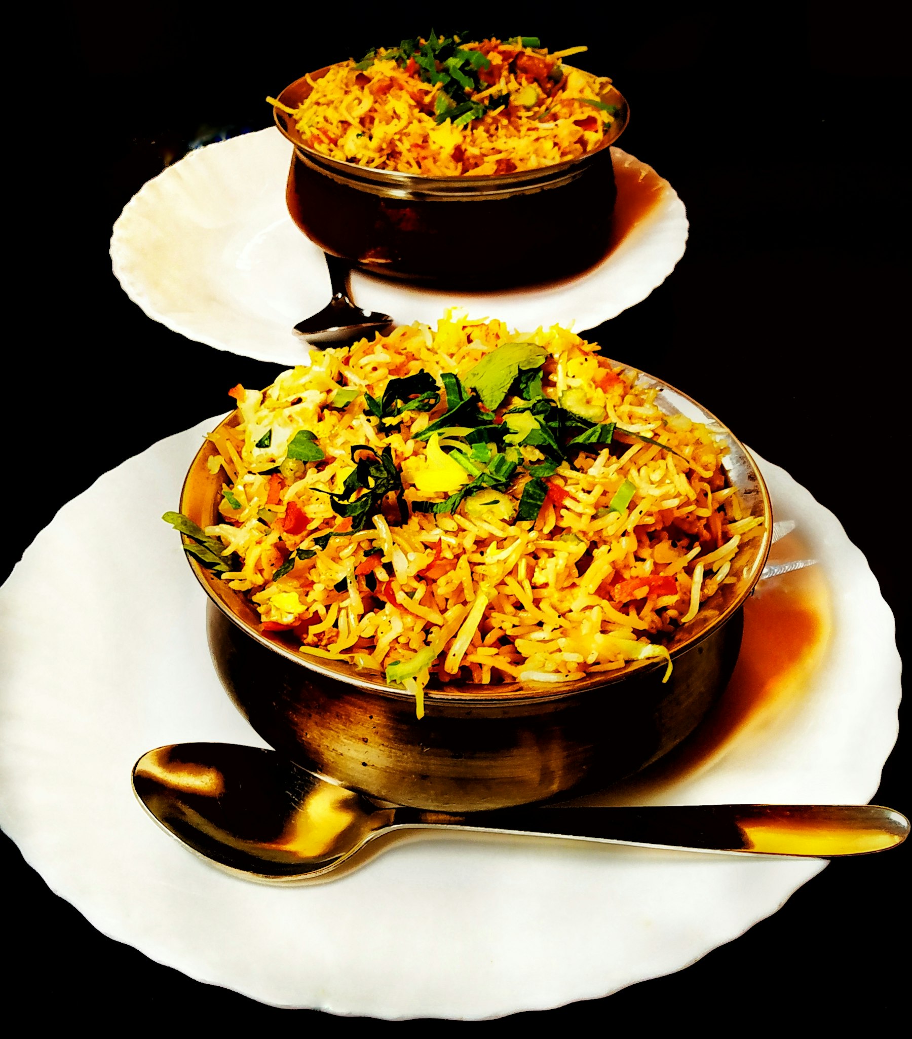 A plated biryani with saffron rice and garnish